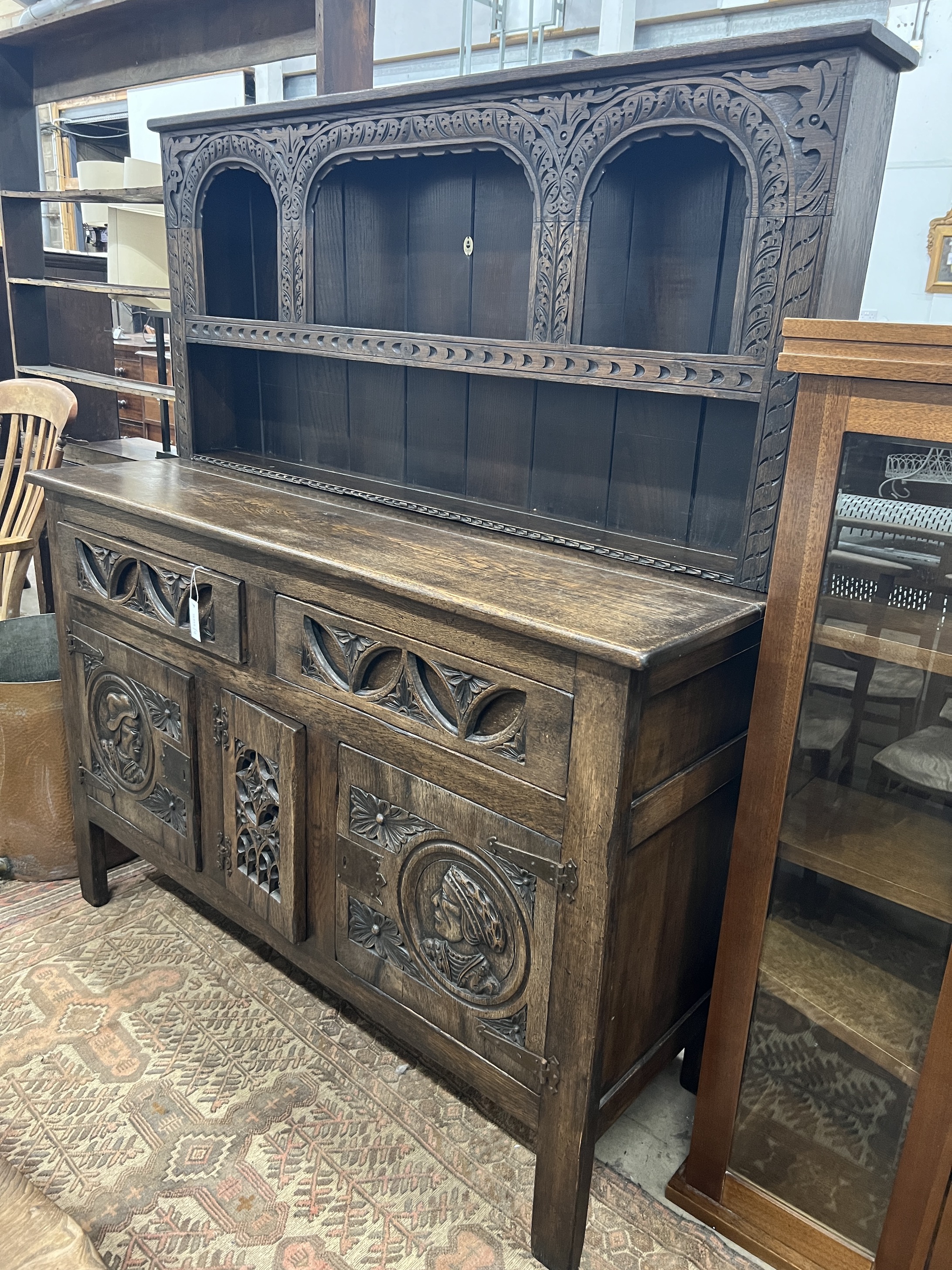 A 17th century style “Tudor Furniture” carved oak dresser, width 146cm, depth 53cm, height 168cm